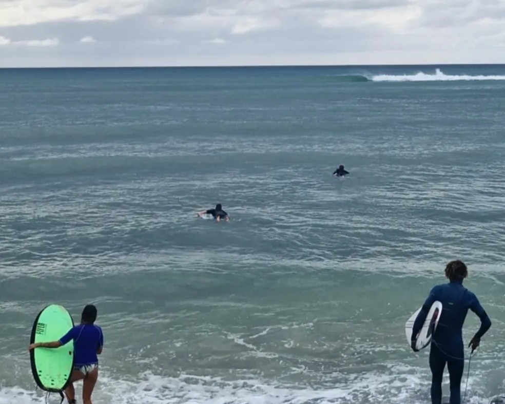 Surf guide entering the ocean with beginner and advanced surfers in Boa Vista