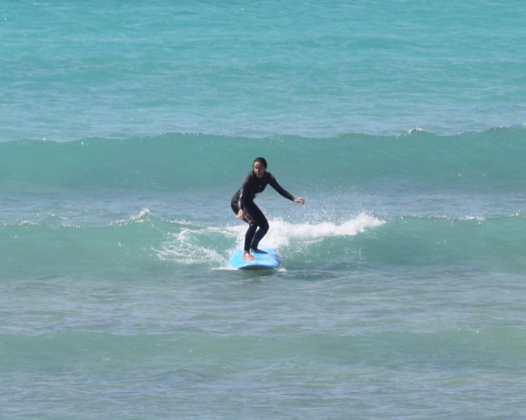 Beginner to intermediate surfer riding a clean wave during a surf lesson in Boa Vista, Cape Verde